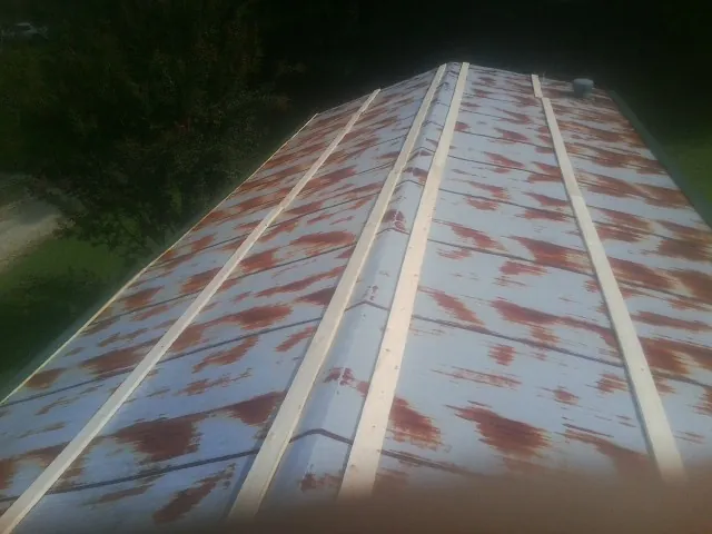 Rusted metal roof panels with new wood purlins before replacement — Storm Damage Roof Repair in Mystic by Roofing Brothers