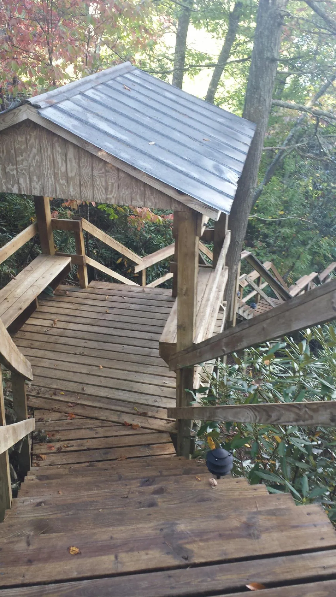 Metal roofed shelter over wooden steps on a wooded walkway — Skylight Repair & Installation work by our crew in Mystic