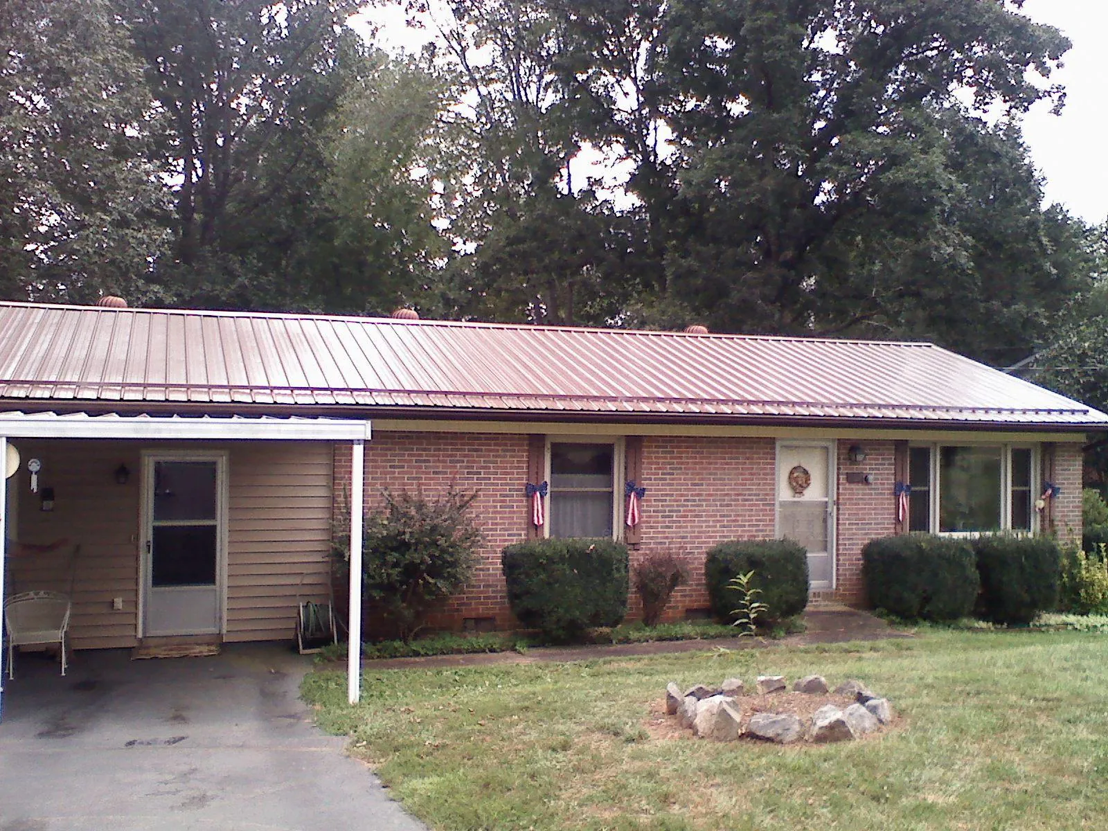 Bronze metal roof and carport on a brick ranch home — Roof Repair work by our crew in Mystic